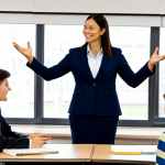 **Prompt for Human-Centric Teaching:**
    A professional female educator in a modest business blazer and trousers, engaging actively with a diverse group of adult students in a modern, bright classroom. She is standing at the front, using expressive hand gestures to explain a concept, fostering a dynamic and positive learning environment. Students are attentively listening and interacting. The classroom features large windows, an interactive whiteboard, and comfortable seating. Fully clothed, modest clothing, appropriate attire, professional dress, perfect anatomy, correct proportions, natural pose, well-formed hands, proper finger count, natural body proportions, safe for work, appropriate content, professional, family-friendly, high-quality, professional photography.